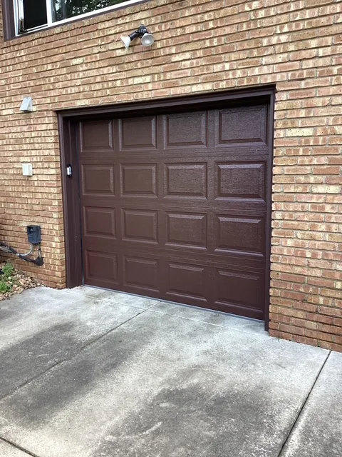 Newly installed dark woodgrain raised-panel garage door on a Midwest garage