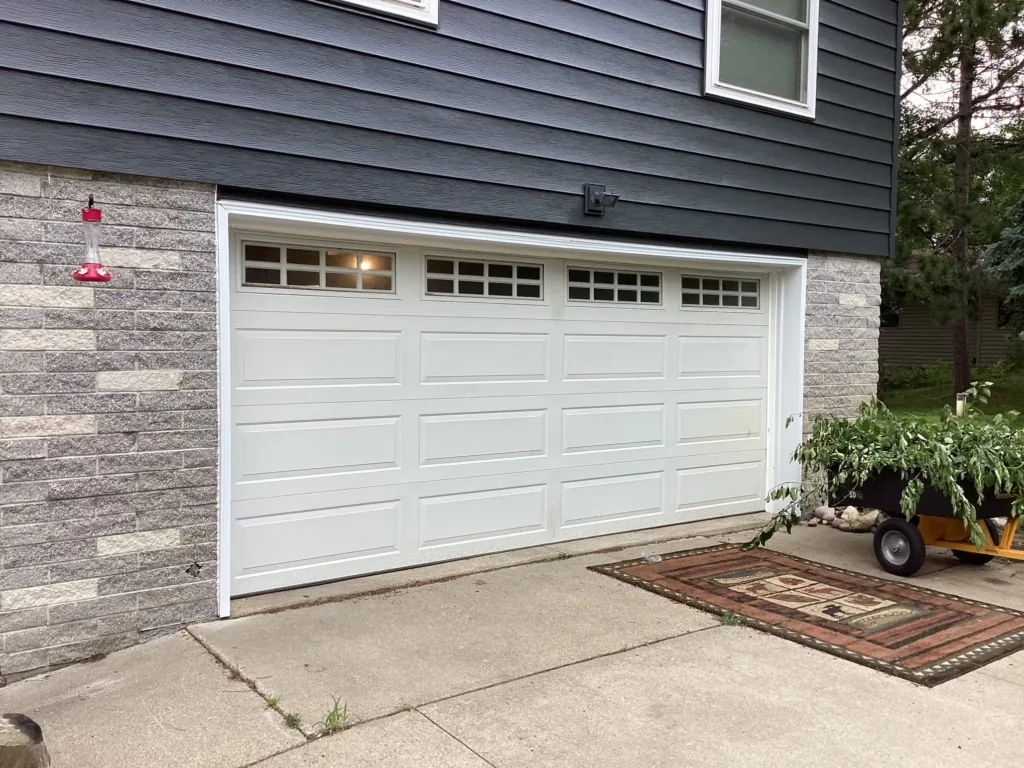 White carriage-style garage door installed on a Midwest home